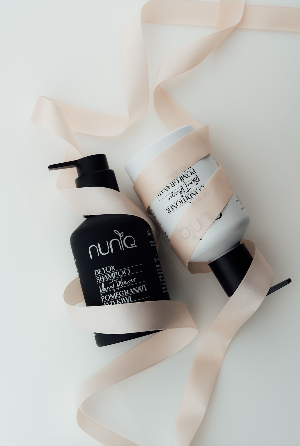 Pink ribbon symbol beside cosmetic products, illustrating the debate around pinkwashing and breast cancer awareness in beauty.