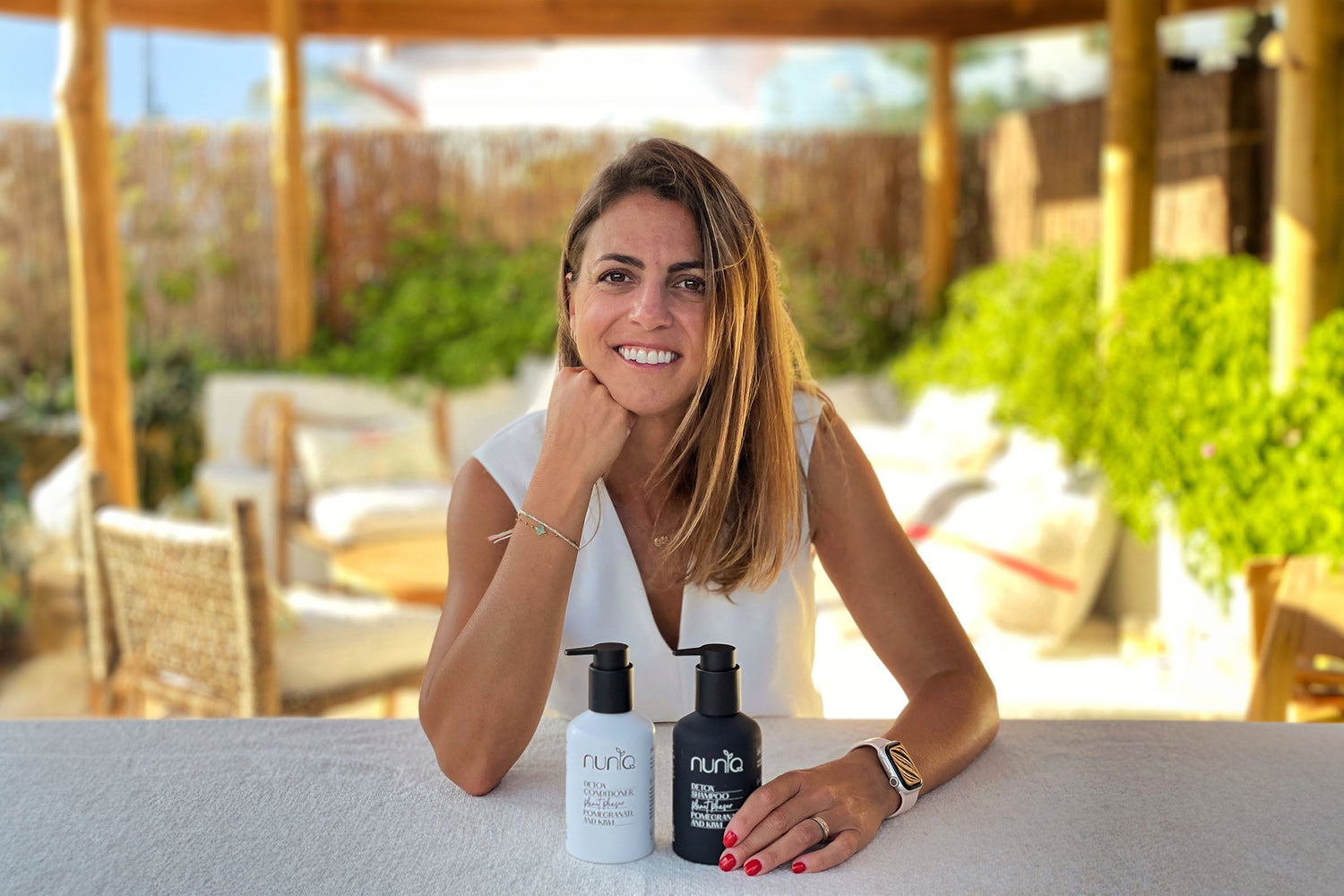 Carmen Escaño,holding Nuniq's clean beauty haircare products.