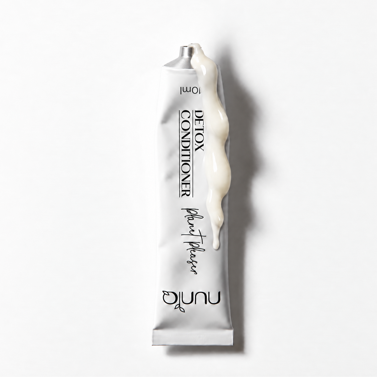 A squeeze tube of Nuniq Plant Based Detox Conditioner, filled with a thick off-white cream and shown against a clean white background with a soft shadow.