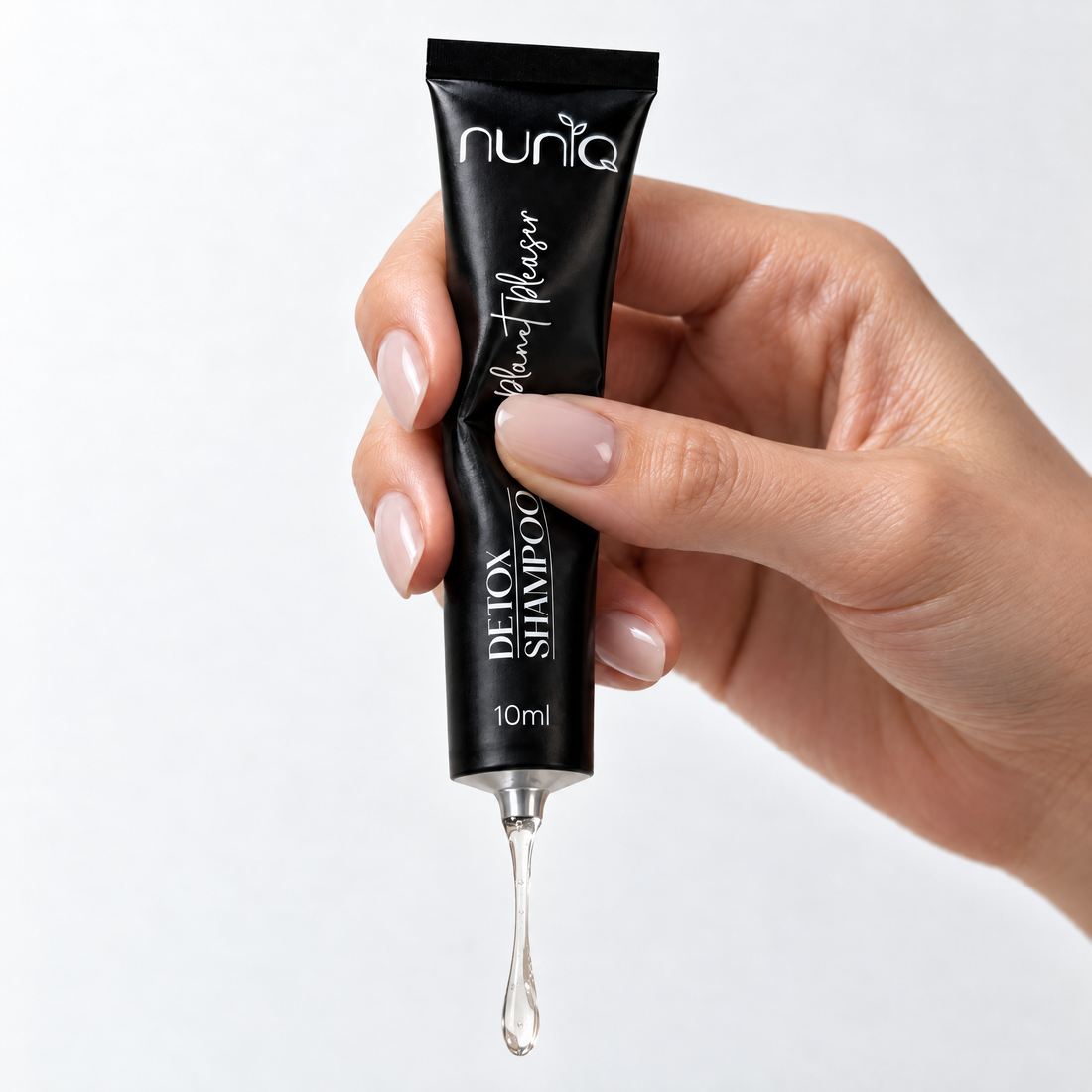 hand is squeezing the tube and the shampoo is coming out